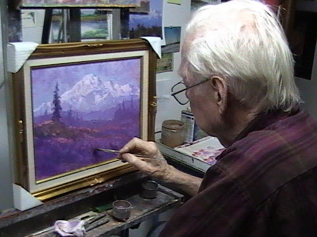 Scott demonstrates touching up a painting.